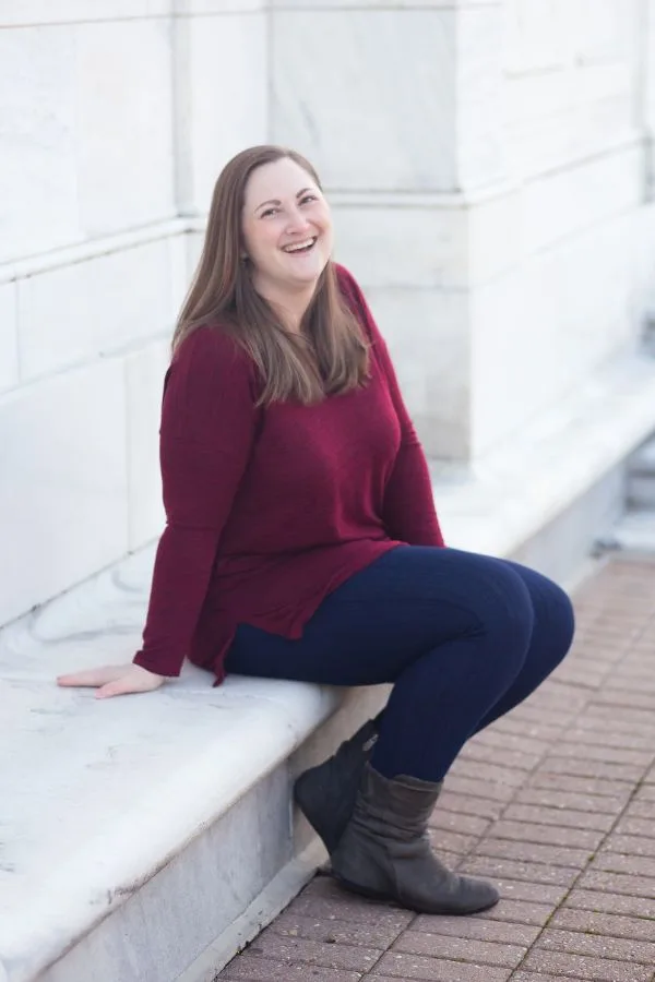 Picture of Rachel sitting on a white bench laughing.