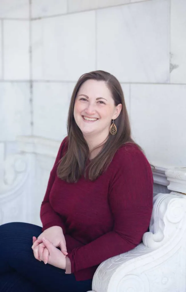 Picture of Rachel smiling on a white bench.