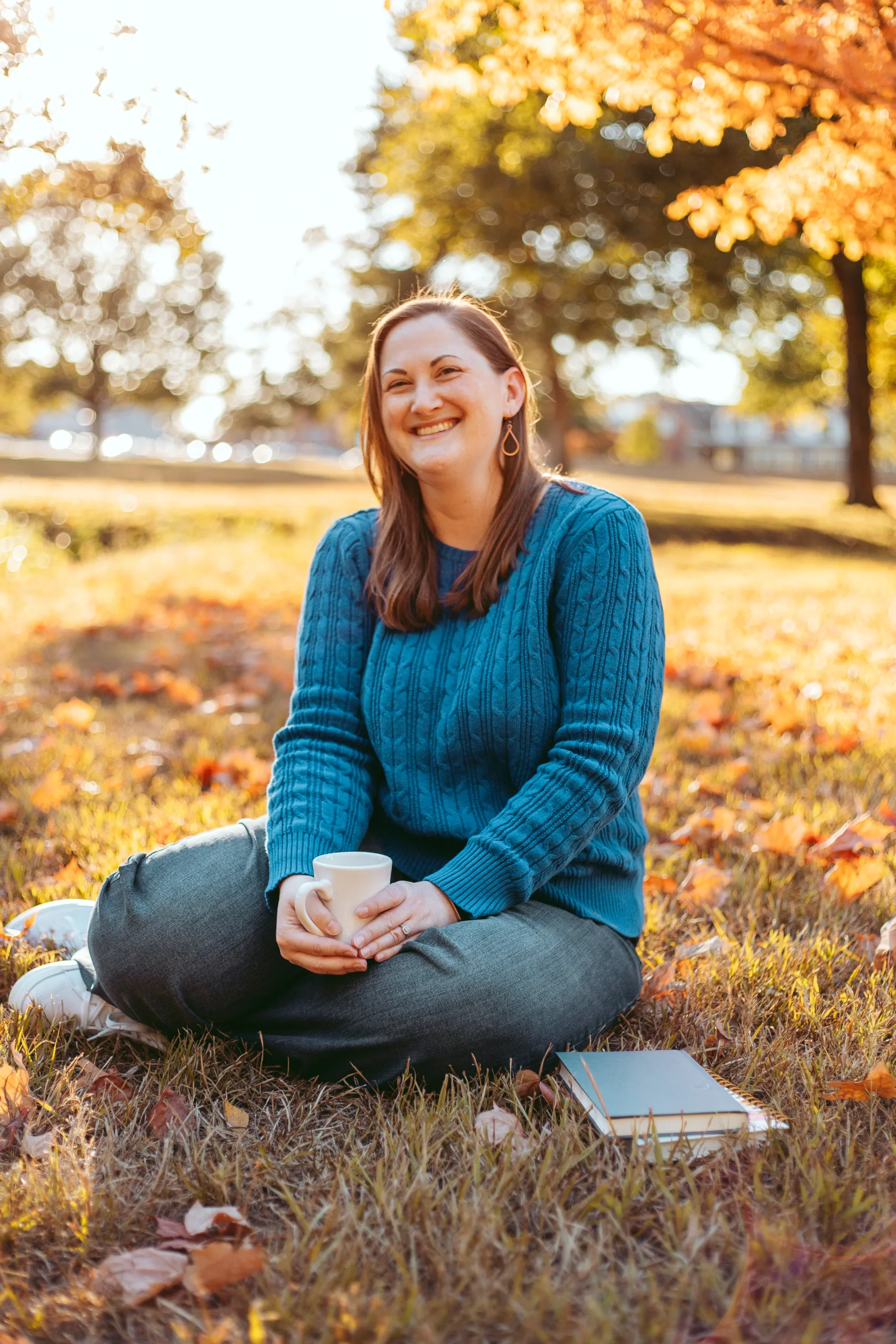 Picture of Rachel sitting in the grass, holding a cup of coffee.