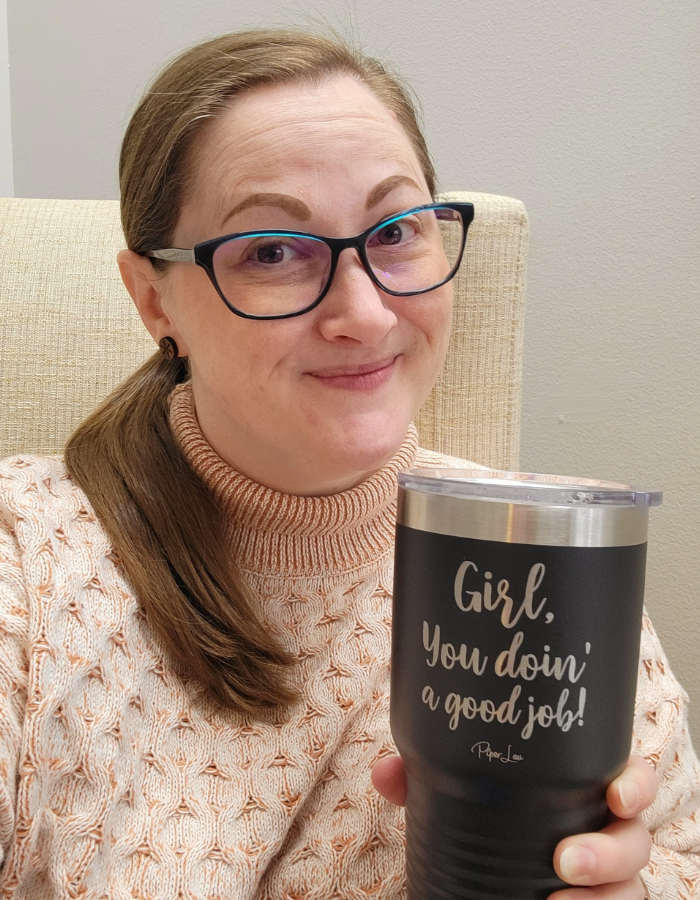 Image of Rachel sitting in a chair with a tumbler that says "Girl you doin' a good job!".